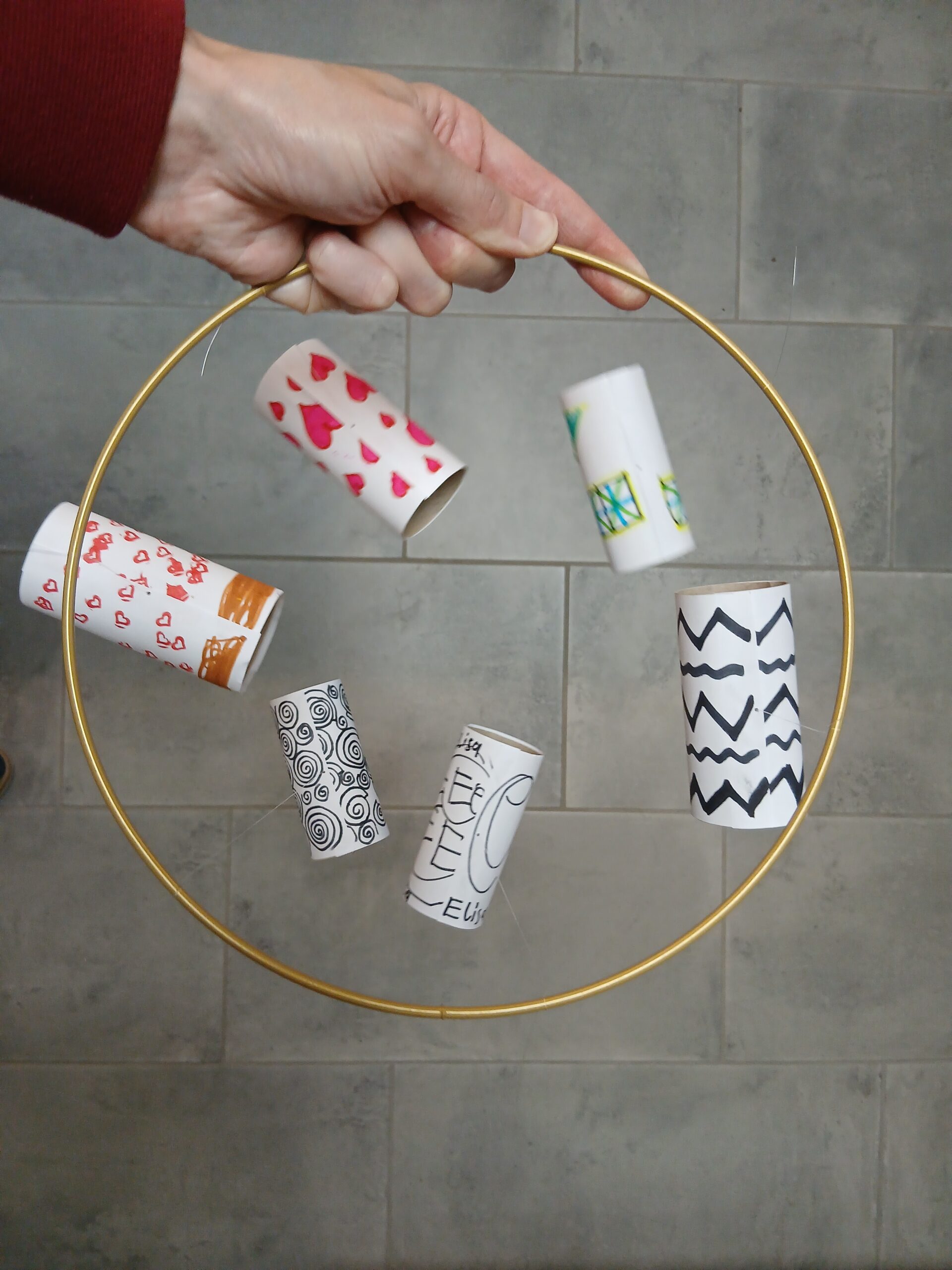 Babymobile aus bemalten Klopapierrollen auf Metallreifen