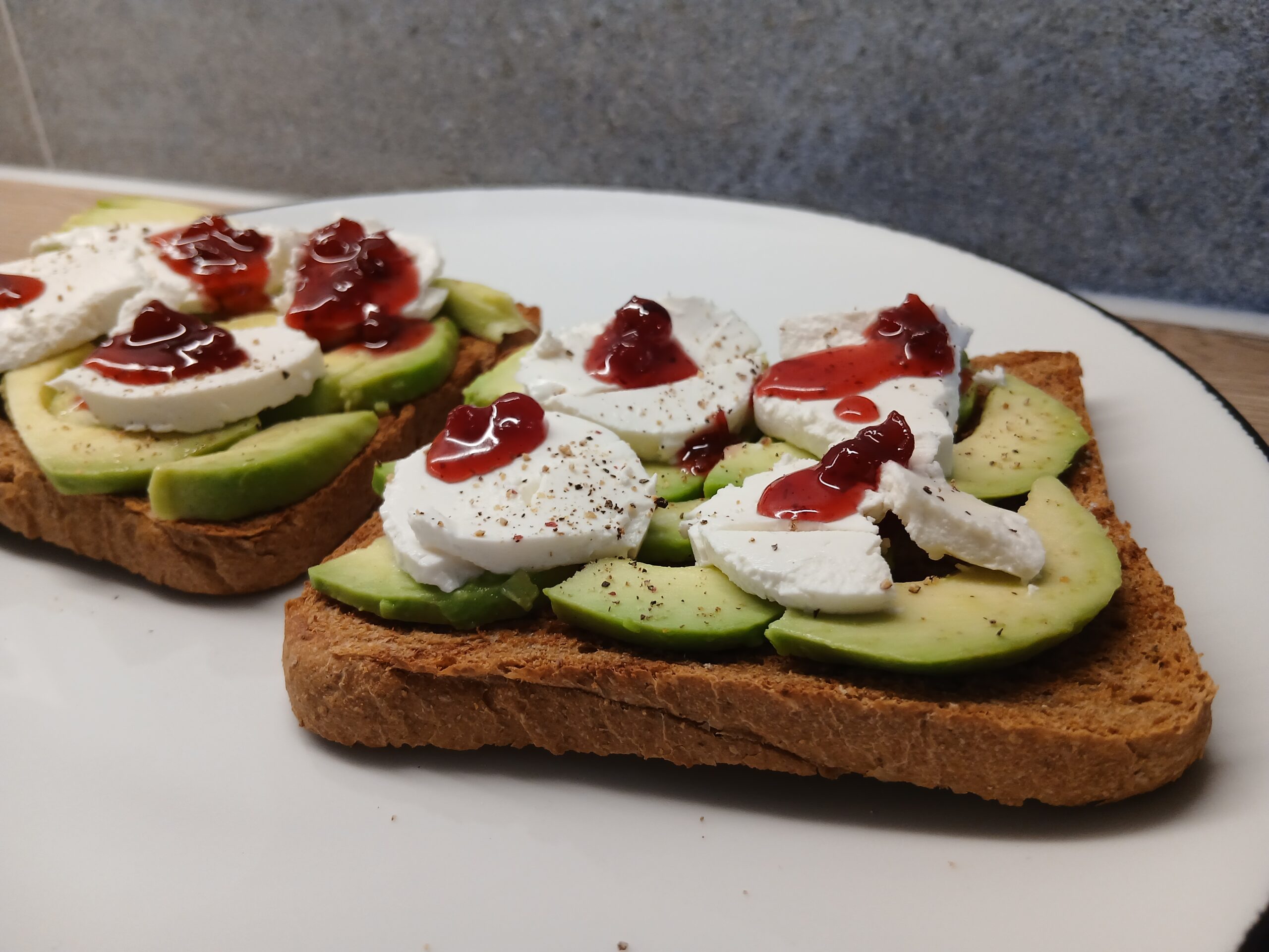 Zwei Avocado-Ziegenkäse Toasts auf einem Teller