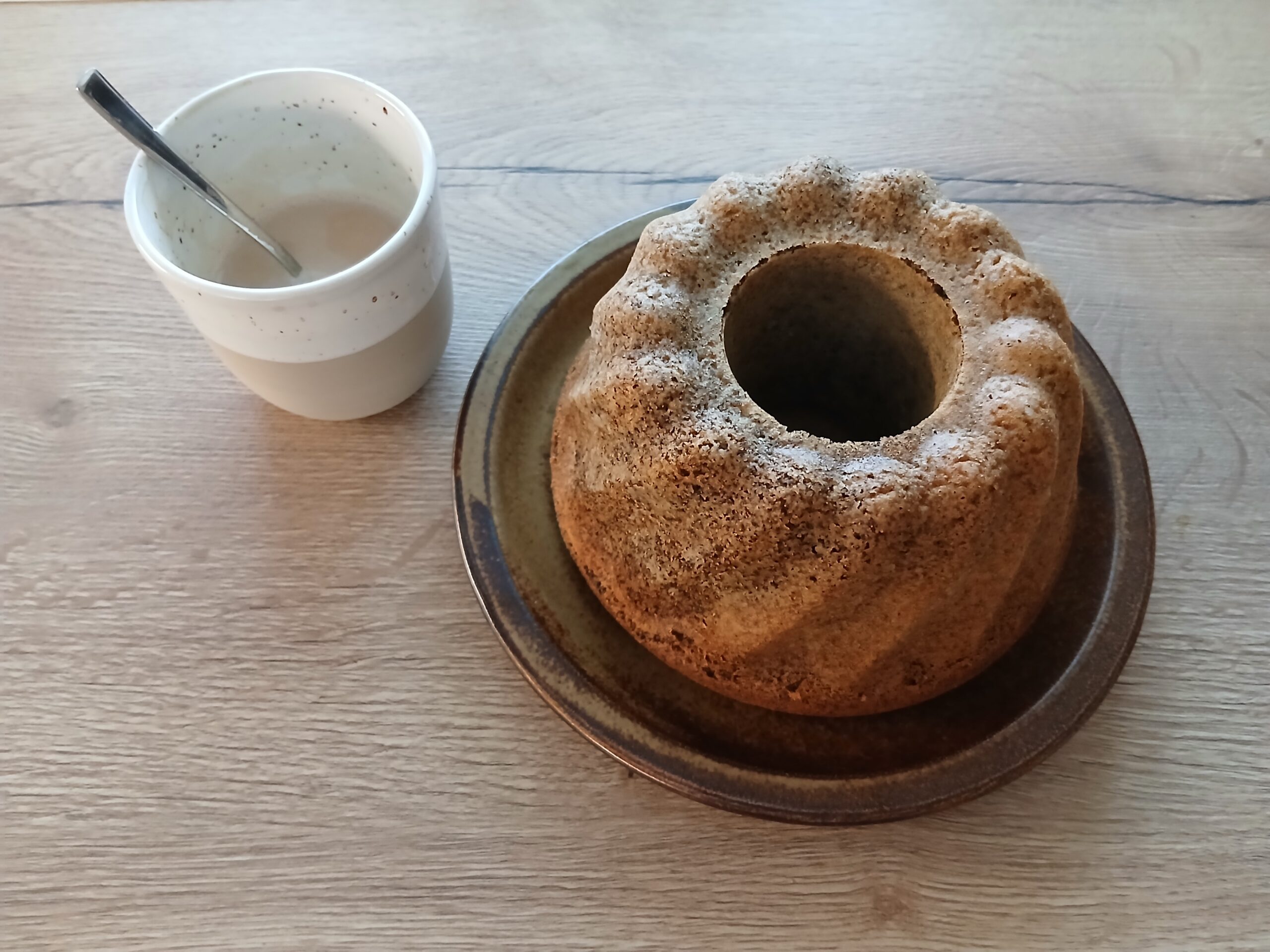 Mohngugelhupf auf einem Teller und eine Tasse Kaffee