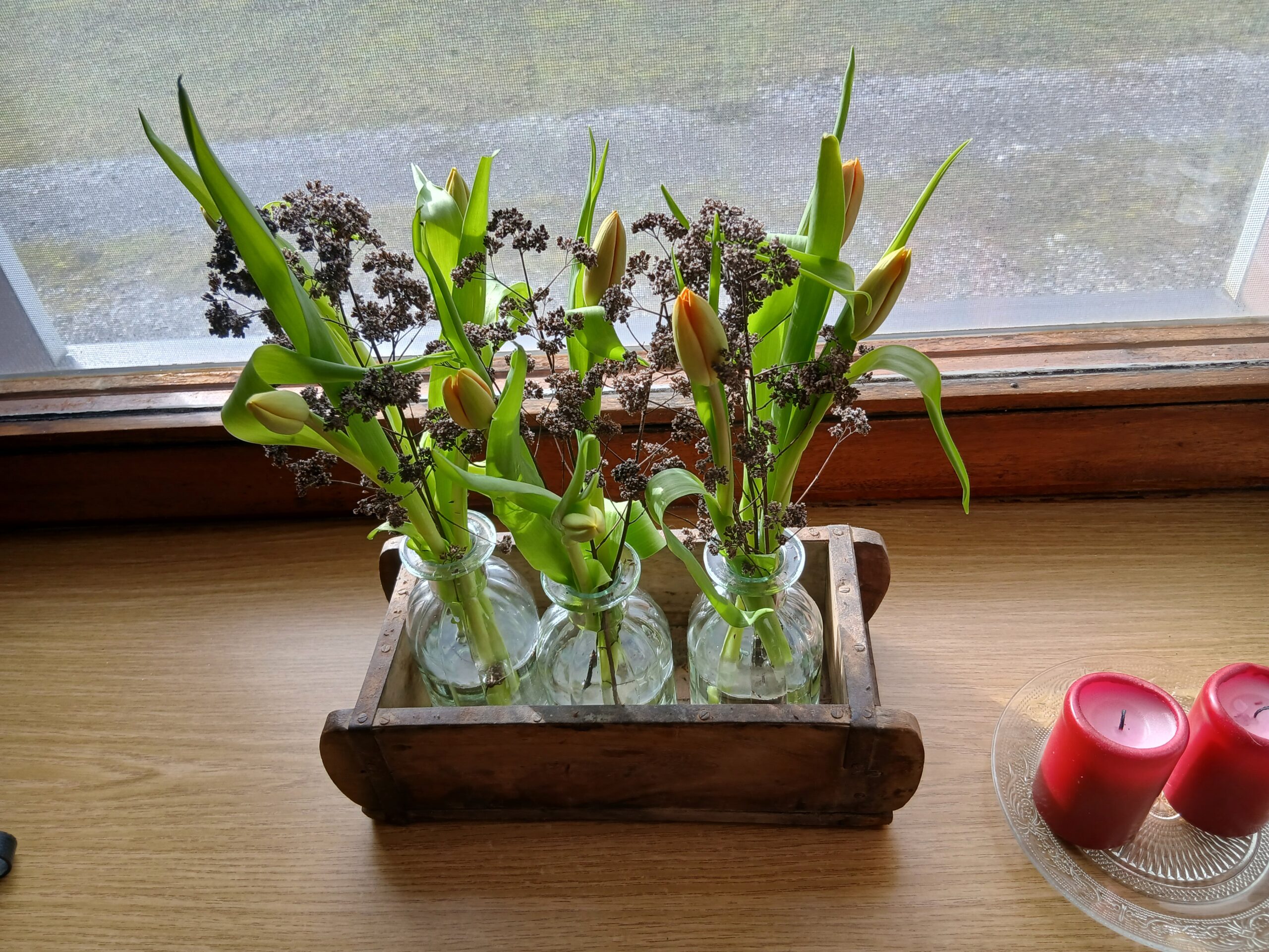 Glasvasen mit Tulpen in einer Ziegelform