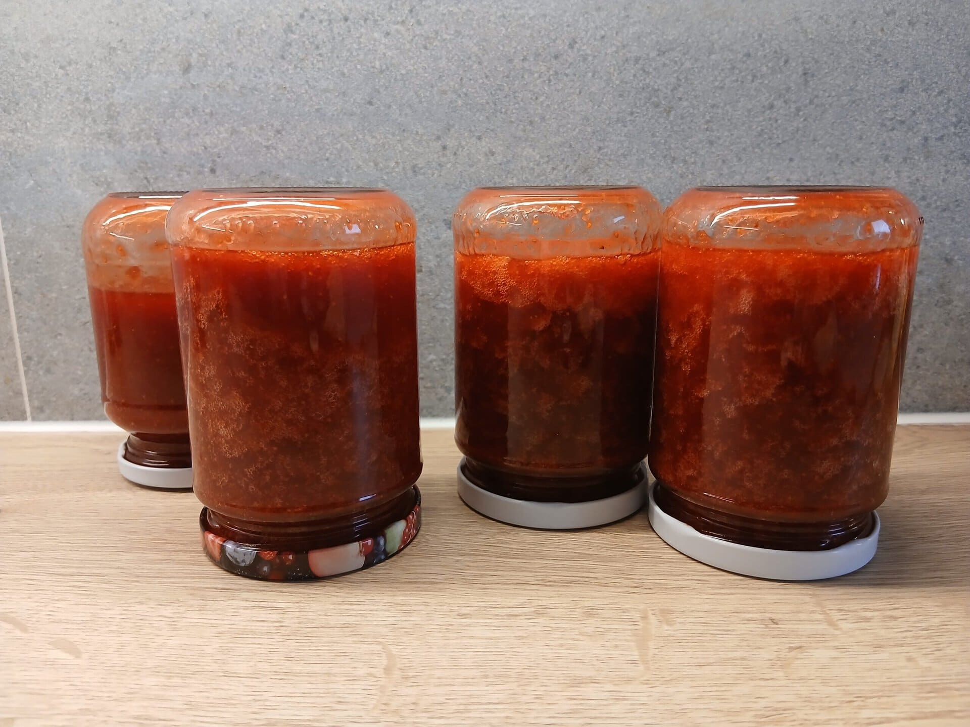 Umgedrehte Einmachgläser mit Erdbeermarmelade
